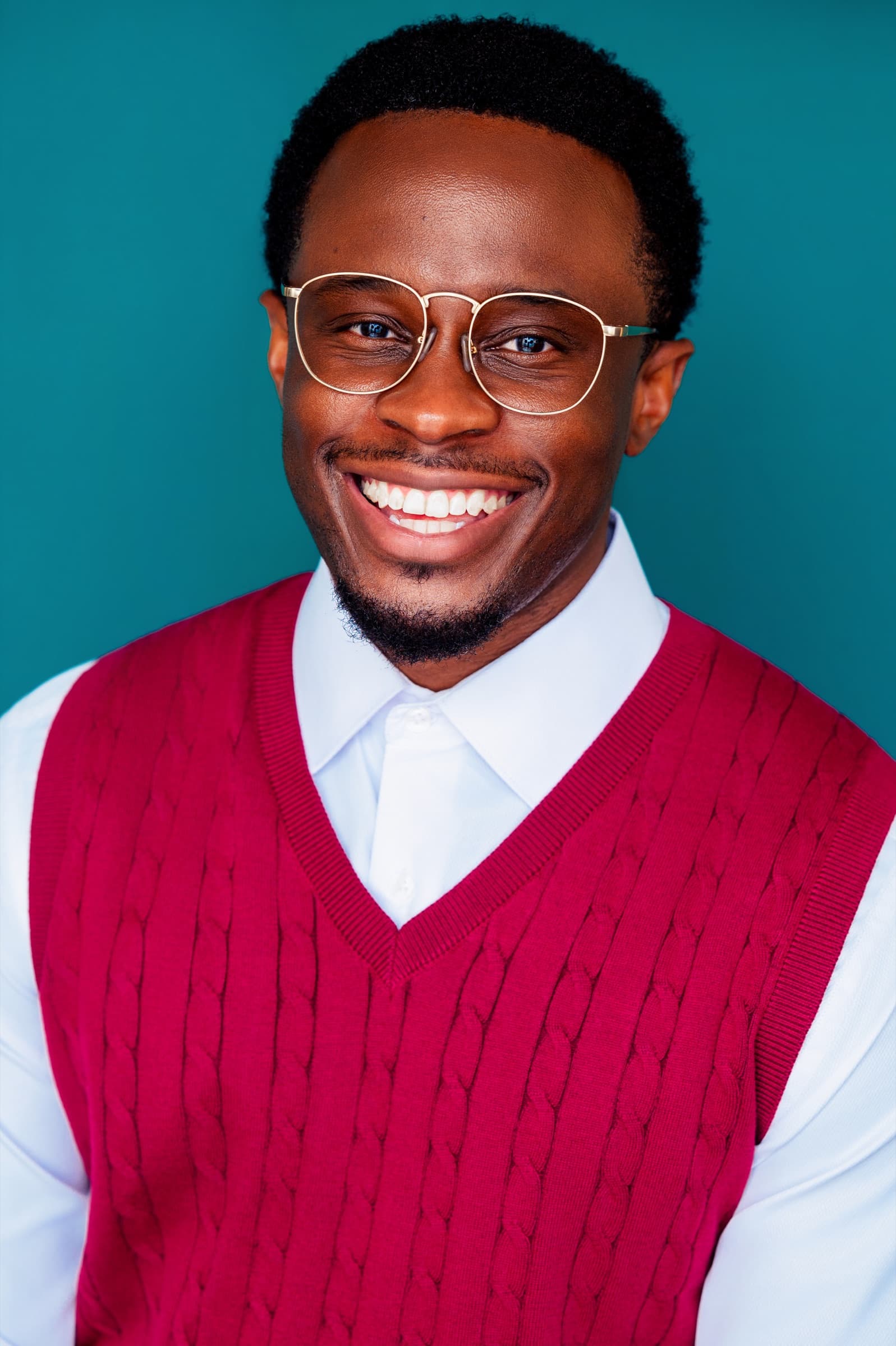 Lanre Adigun headshot — maroon sweater vest